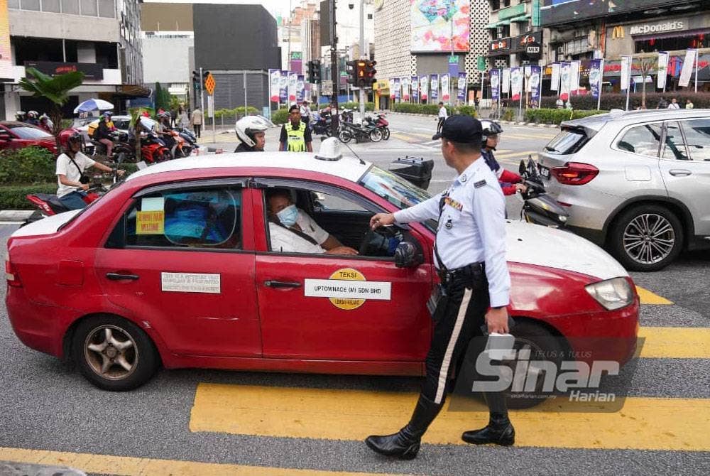 Seorang anggota polis menahan pesalah lalu lintas semasa Operasi Hormat Undang-Undang Jalan Raya Polis Kuala Lumpur dilakukan di Kuala Lumpur pada Isnin. Foto: SINAR HARIAN/Rosli Talib.