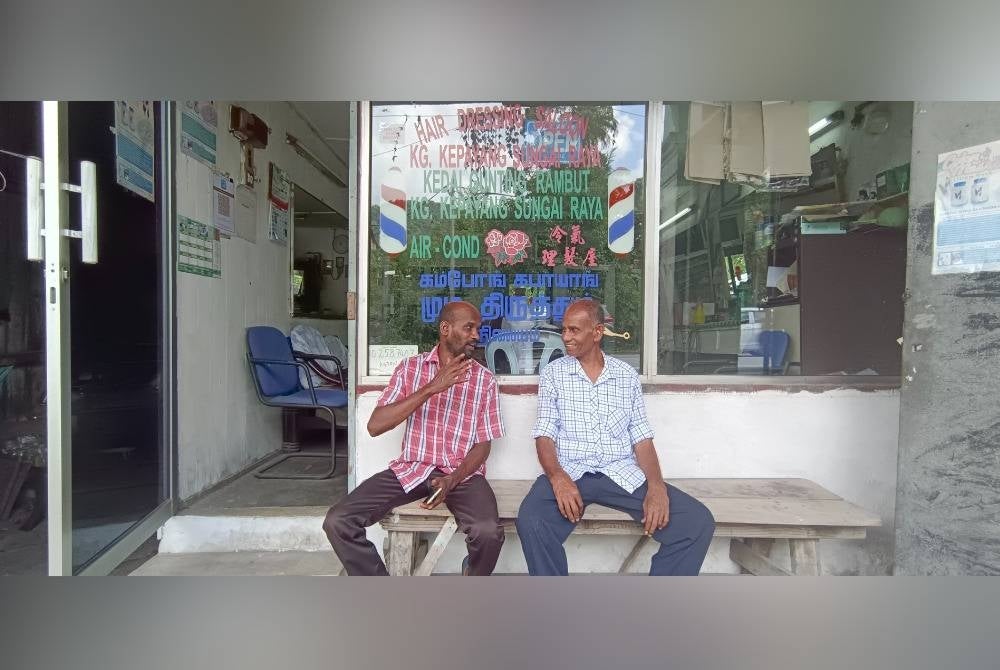 Gnasergaran (kanan) berbual dengan saudaranya yang turut bekerja menggunting rambut di kedainya di Kampung Kepayang, Sungai Raya.