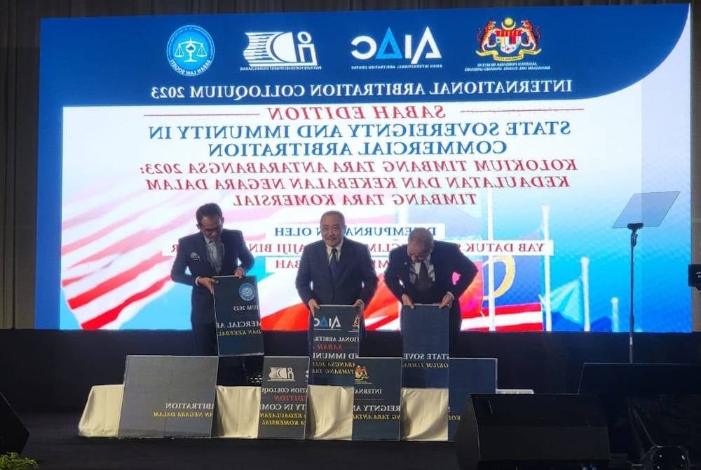 Hajiji (tengah) diiringi Wan Junaidi (kiri) dan Khairul Dzaimee (kanan) menyempurnakan perasmian Kolokium Timbang Tara Antarabangsa 2023: Kedaulatan Negara dan Kekebalan dalam Penyelesaian Pertikaian Komersial yang diadakan di SICC Kota Kinabalu pada Selasa.