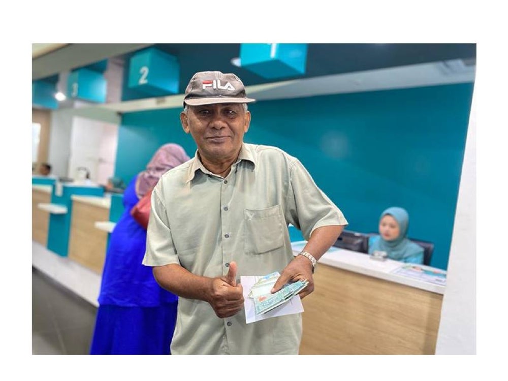 Md Jalil menunjukkan wang STR yang diterimanya di kaunter BSN.