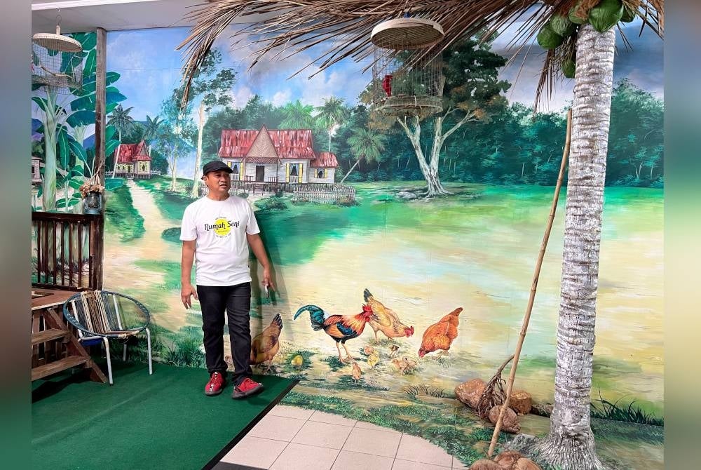 Zulkefli menunjukkan lukisan mural yang dihasilkan berlatar belakangkan Kampung Palembang, sebuah lokasi daerah Kluang. - Foto Bernama