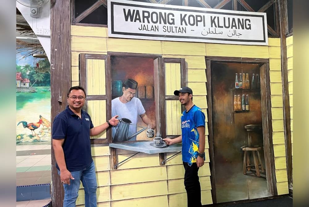 Muhamad Nasir (kiri) beraksi di sebuah lukisan mural tiga dimensi (3D) yang dihasilkan oleh bekas kartunis yang juga pelukis mural, Zulkefli Dahlan yang dihasilkan di dalam rumah banglo yang dikenali sebagai Rumah Seni. - Foto Bernama