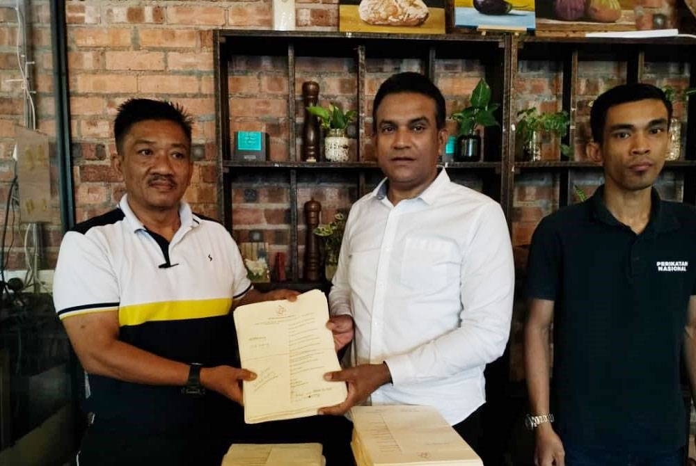 Mohd Ridzuan (tengah) menerima borang pungutan suara Proklamasi Melayu daripada Kamalariffin (kiri) di Kluang pada Selasa.
