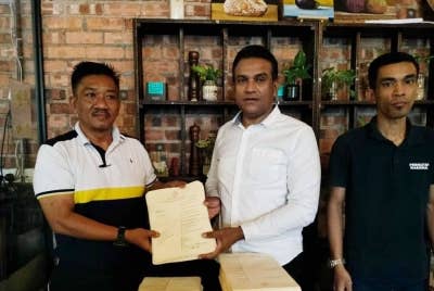 Mohd Ridzuan (tengah) menerima borang pungutan suara Proklamasi Melayu daripada Kamalariffin (kiri) di Kluang pada Selasa.