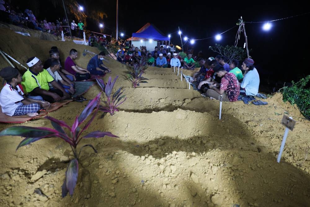 Jenazah tujuh beranak selamat dikebumikan di Tanah Perkuburan Islam Felda Lebar Hilir 3 pada malam Selasa. - Foto Bernama