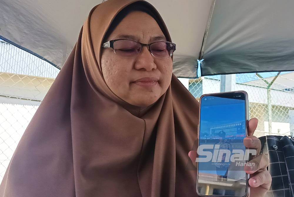 Norizan menunjukkan gambar kenangan Allahyarham Muhamad Irfan Irham pada sesi tamat latihan di Pusat Latihan Polis Langkawi Januari lepas.