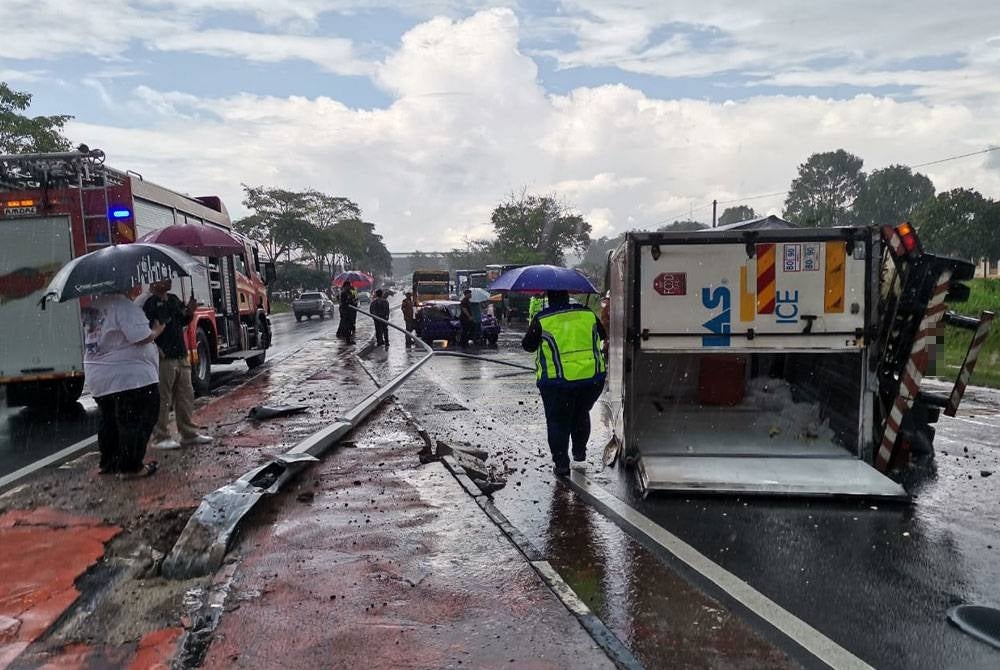 Sebuah lori muatan ais terbalik selepas melanggar kereta Perodua Kancil di Kilometer 58.5 Jalan Batu Pahat-Mersing dekat Kluang pada Rabu. - Foto bomba Johor