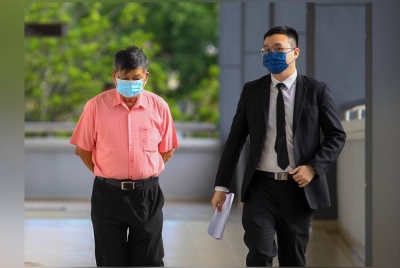 Kok Keong (kiri) bersama peguamnya ketika tiba di mahkamah.