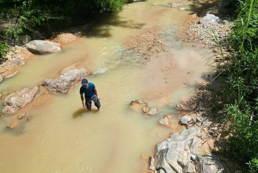 Mohd Sobri mengambil sampel air Sungai Chepir yang agak keruh dipercayai akibat aktiviti projek berkenaan. - Foto GRASS Kedah