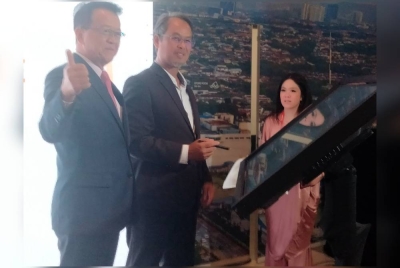 Jeffrey (kiri) mengiringi Mohamad Azhan menandatangani plak perasmian.