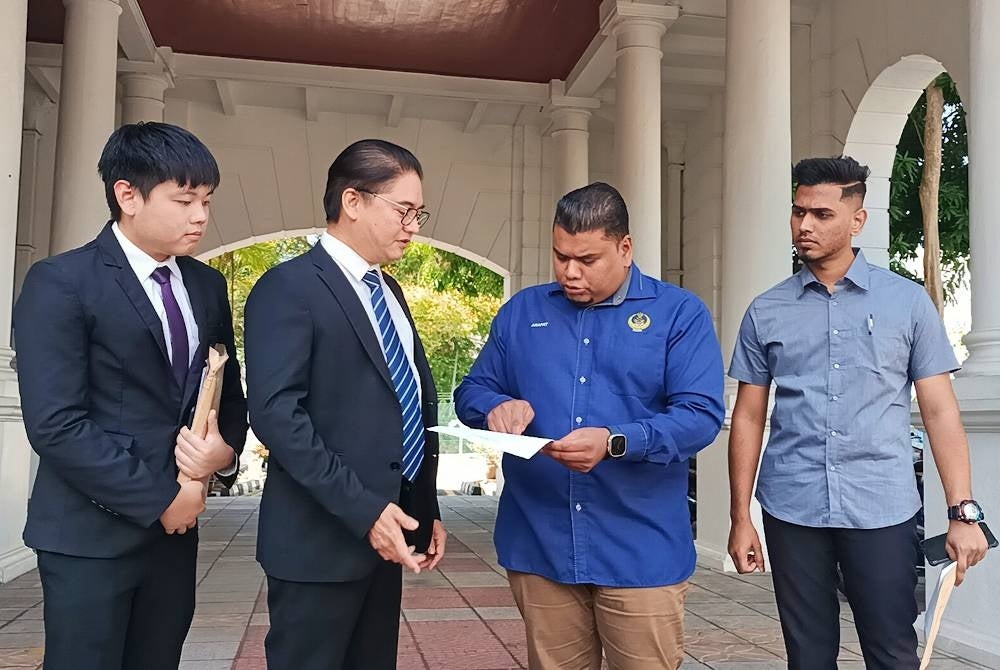 Muhamad Arafat (dua dari kanan) hadir bersama Peguamnya, Terence Naidu (dua dari kiri) ketika ditemui di pekarangan Mahkamah Tinggi Ipoh pada Jumaat.