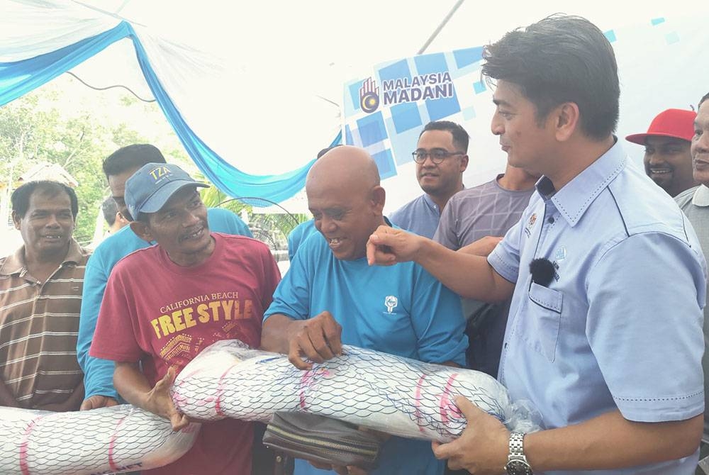 Muhammad Faiz (kanan) berbual dengan nelayan pada penyampaian bantuan peralatan selepas Program Rahmah Mesra Madani bersama Nelayan Kuala Selangor di Hab Nelayan Sungai Sembilang di sini pada Jumaat.