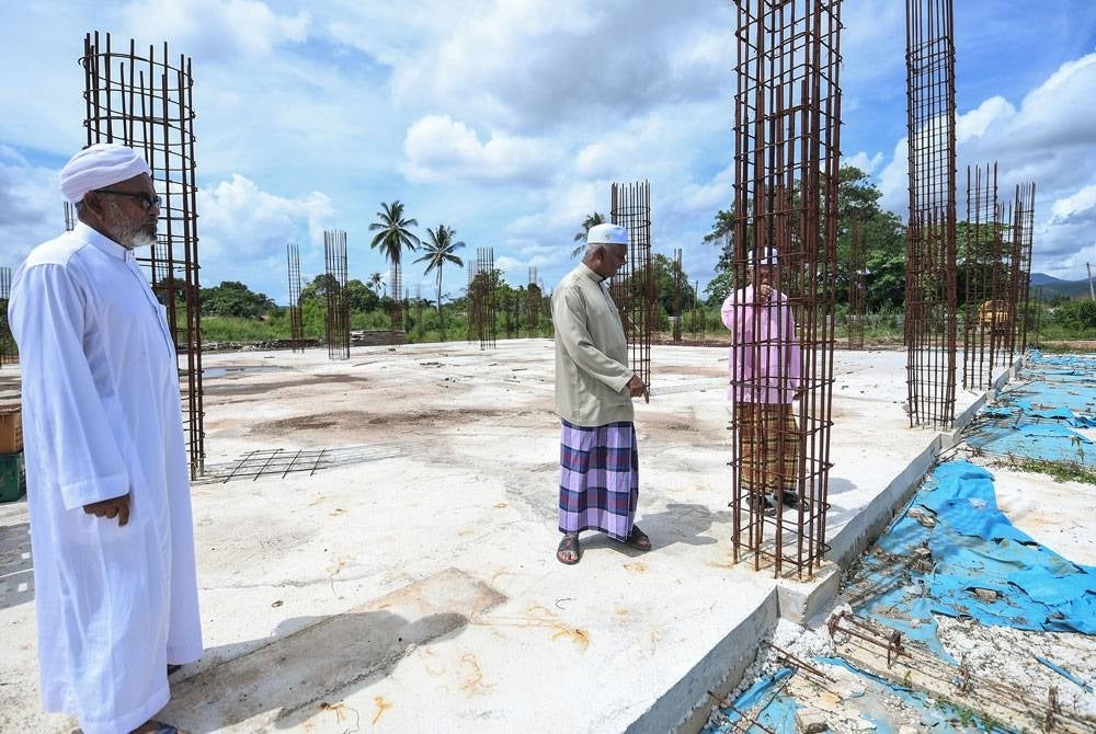 Zainol Abidin (tengah) bersama Penolong Setiausahanya, Abu Bakar Mat Safar, 63, (kiri) melawat tapak masjid baharu pada Jumaat. - Foto Bernama