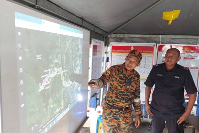 Azman (kiri) dan Hanyan (kanan) ketika menunjukkan lokasi pencarian.