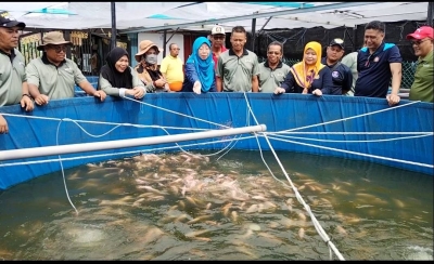 Suraya (lima, kiri), memberi makan kepada ikan ketika melawat taman Akuagro di RT Bachang, pada Jumaat. 