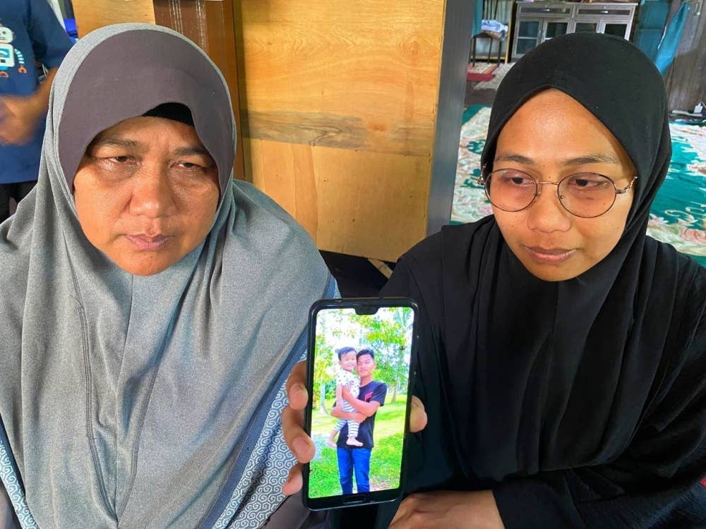 Kartina Athira (kanan) dan ibunya menunjukkan gambar Mohammad Afiq.