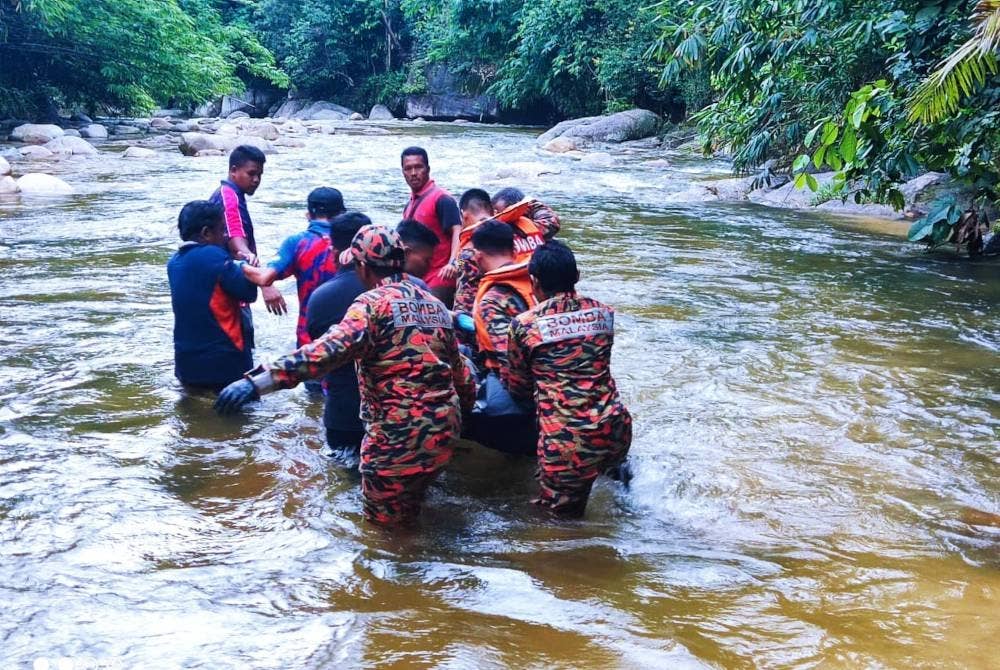 Anggota bomba membawa mayat mangsa keluar dari kawasan sungai sebelum diserahkan kepada polis. - Foto Bomba Perak