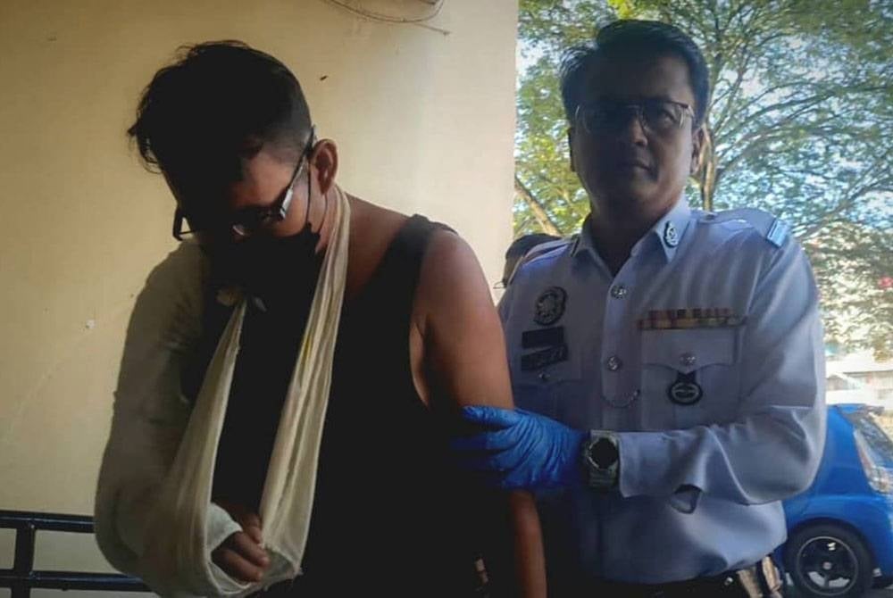 Tertuduh (kiri) ketika dibawa ke mahkamah pada Isnin.