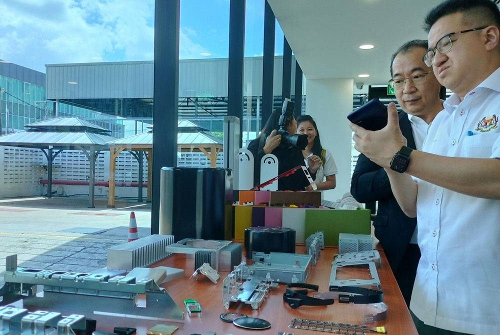 Liew Chin Tong (kanan) melihat produk yang dihasilkan ketika mengadakan lawatan ke sebuah syarikat pembuatan di Sungai Petani pada Isnin.