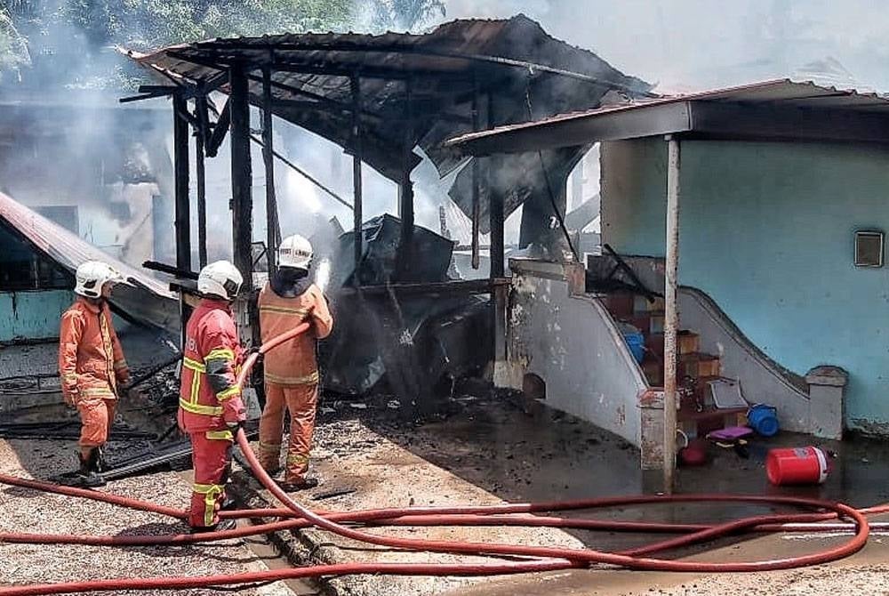 Anggota melakukan kerja-kerja memadam kebakaran madrasah tahfiz di Jalan Dato Dol Said di Taboh Naning, di sini pada Isnin.
