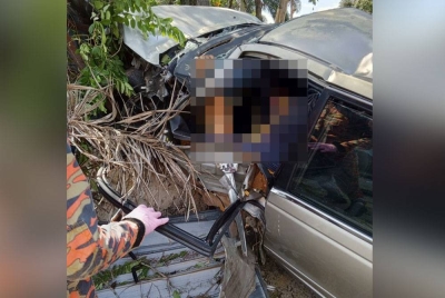 Bomba menjalankan operasi mengeluarkan mangsa yang tersepit dalam kereta yang terbabas di Jalan Gopeng-Kota Bharu di Gopeng pada Isnin. - Foto ihsan Bomba Perak