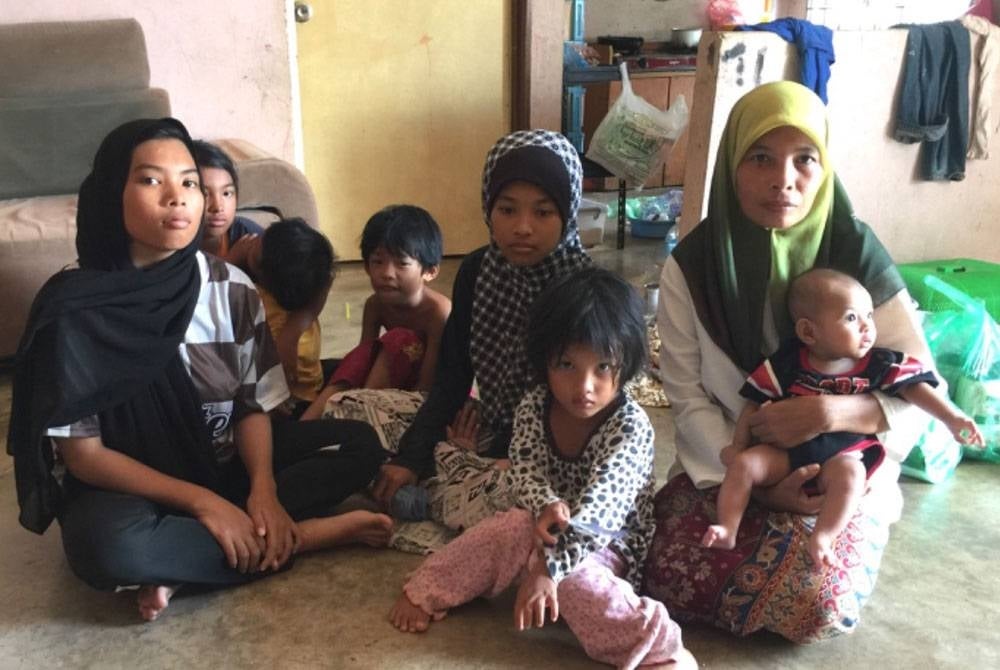 Azleen (kanan) memangku bayi bongsu bersama enam lagi anaknya.