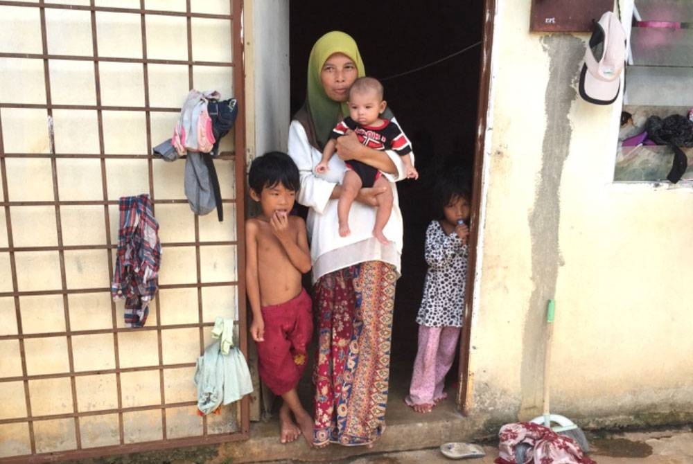 Azleen (tengah) sekeluarga tinggal di sebuah rumah terbengkalai.