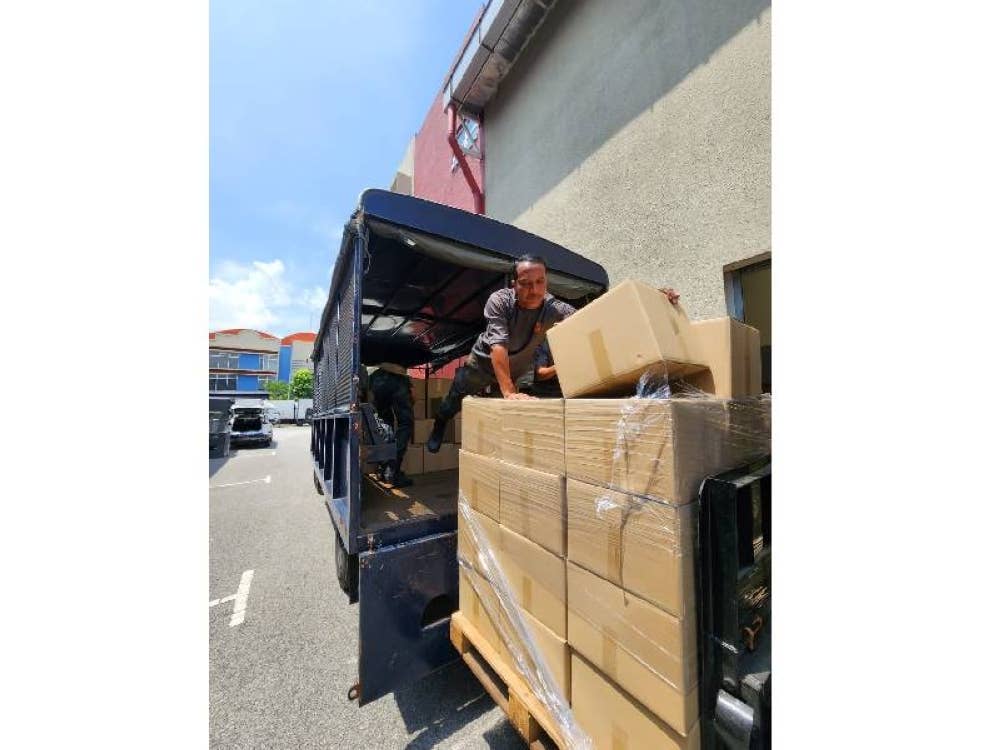 Kakitangan Yayasan Al-Manjie sedang menyusun barangan inisiatif Bakul Rahmah.