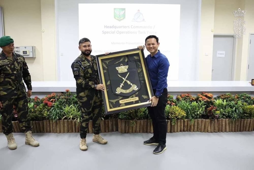 Tunku Ismail (kiri) menerima cenderamata daripada Zaqy semasa melawat SAF di Kem Pasir Ris, Singapura, pada Rabu