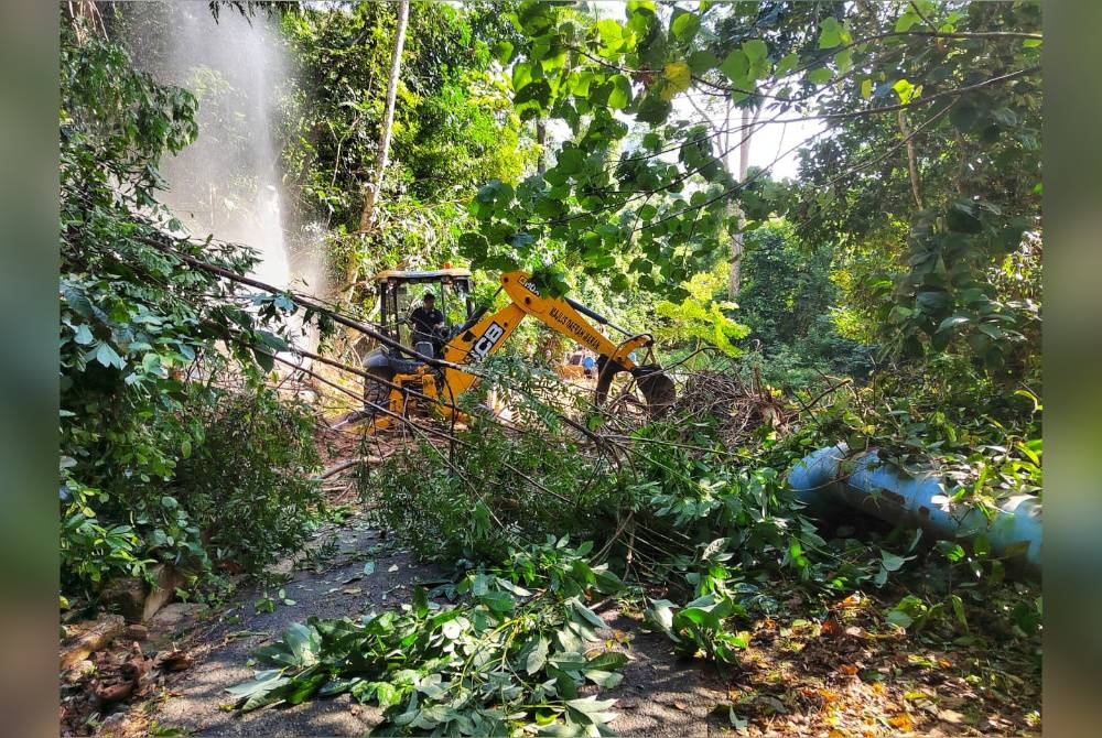 Jengkaut digunakan bagi mengalihkan sisa-sisa runtuhan tanah untuk memberikan akses kepada anggota bomba naik ke lokasi kejadian.- Foto Ihsan JBPM