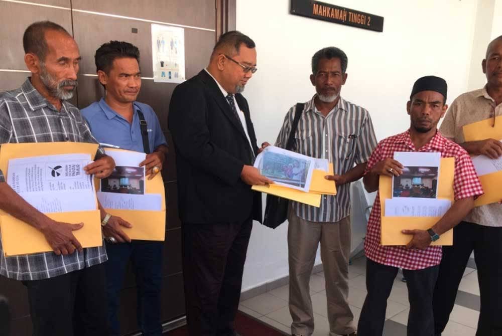 Hisham (tiga dari kiri) melihat dokumen berkaitan kes.