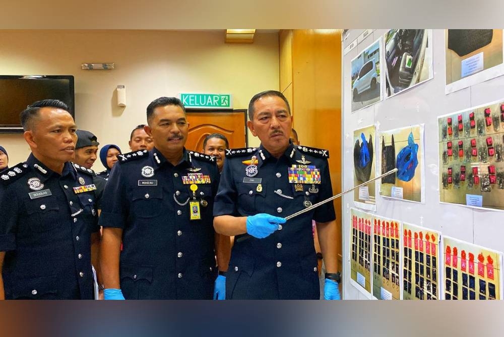 Muhamad Zaki (kanan) menunjukkan kejayaan sepanjang Ops Tapis Khas bermula 5 Julai hingga Selasa.