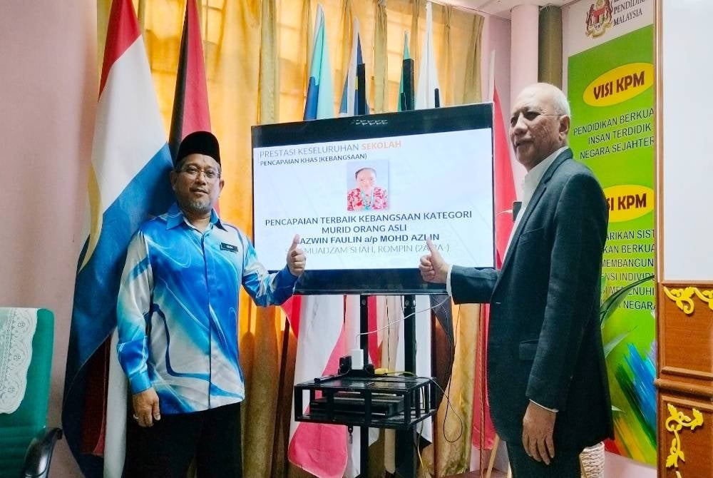 Abdul Rahim (kiri) dan Mohd Soffi (kanan) menunjukkan calon dengan pencapaian terbaik kebangsaan bagi kategori Orang Asli selepas sidang akhbar pengumuman keputusan STPM 2022 Sekolah-Sekolah Negeri Pahang di SMK Astana pada Khamis.