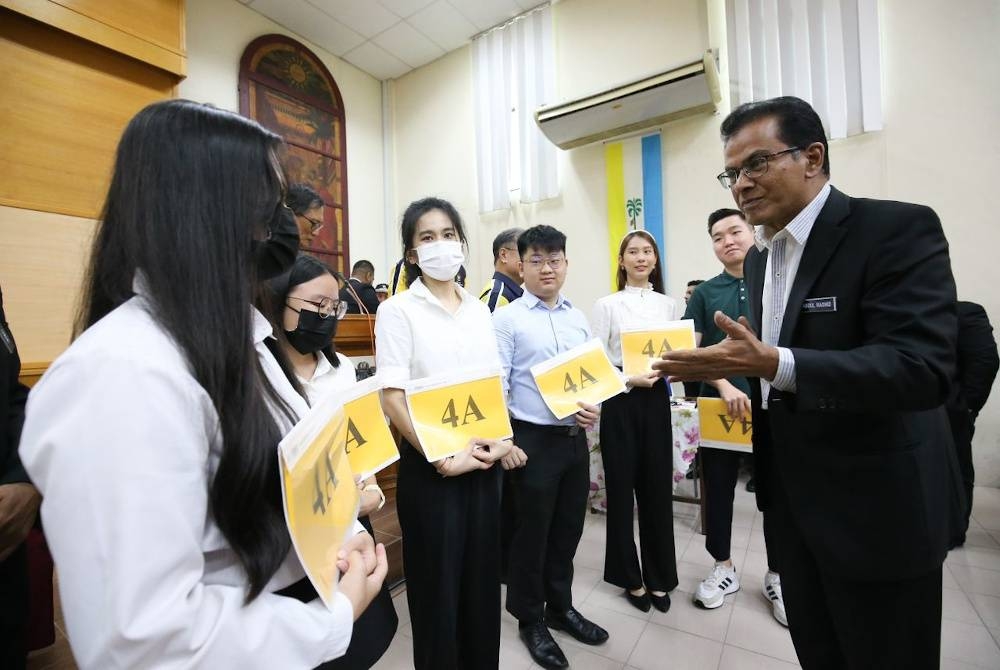 Abdul Rashid (kanan) mengucapkan tahniah kepada pelajar cemerlang STPM 2022 di SMK (L) Methodist pada Rabu.