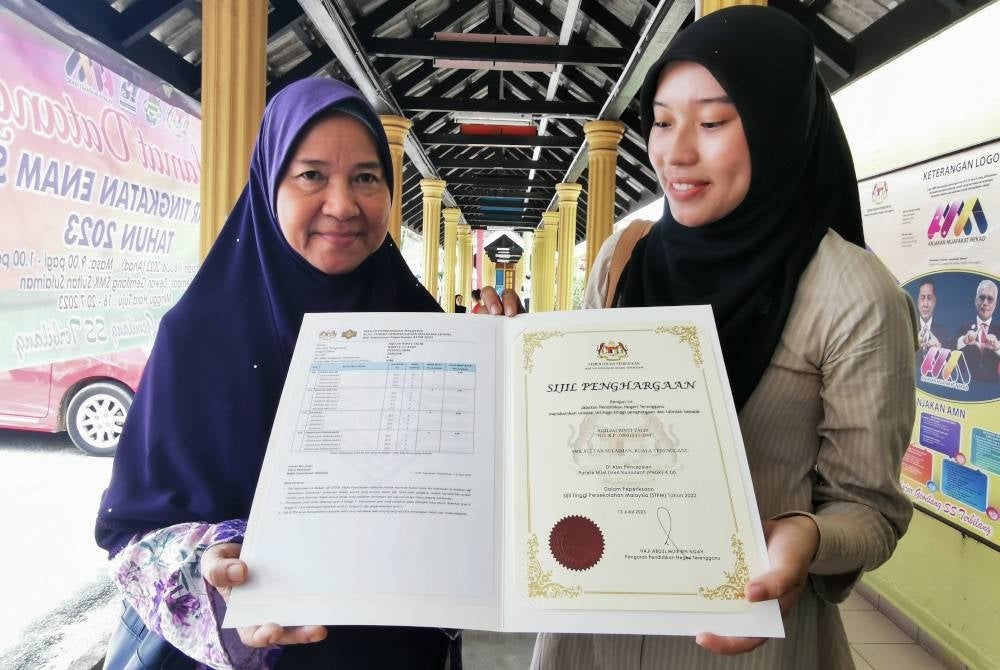 Aqilah (kanan) bersama ibunya, Mariam selepas menerima keputusan STPM di SMK Sultan Sulaiman di Kuala Terengganu pada Khamis.