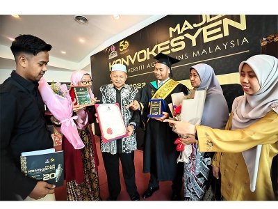 Muhammad Hanif (tiga dari kanan) gembira di samping ibu bapa dan adik-beradiknya yang hadir meraikannya pada Majlis Konvokesyen UCAM kali ke-20.