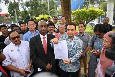  Ahmad Farhan Fauzi menunjukkan salinan laporan polis yang dibuat di Ibu Pejabat Polis Daerah Putrajaya pada Khamis. 