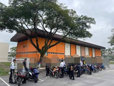 Anggota polis memeriksa beberapa motosikal yang ditahan menerusi Ops Didik yang dijalankan di kawasan parkir Arena Bandar Baru Salak Tinggi (BBST) di sini pada Jumaat.
