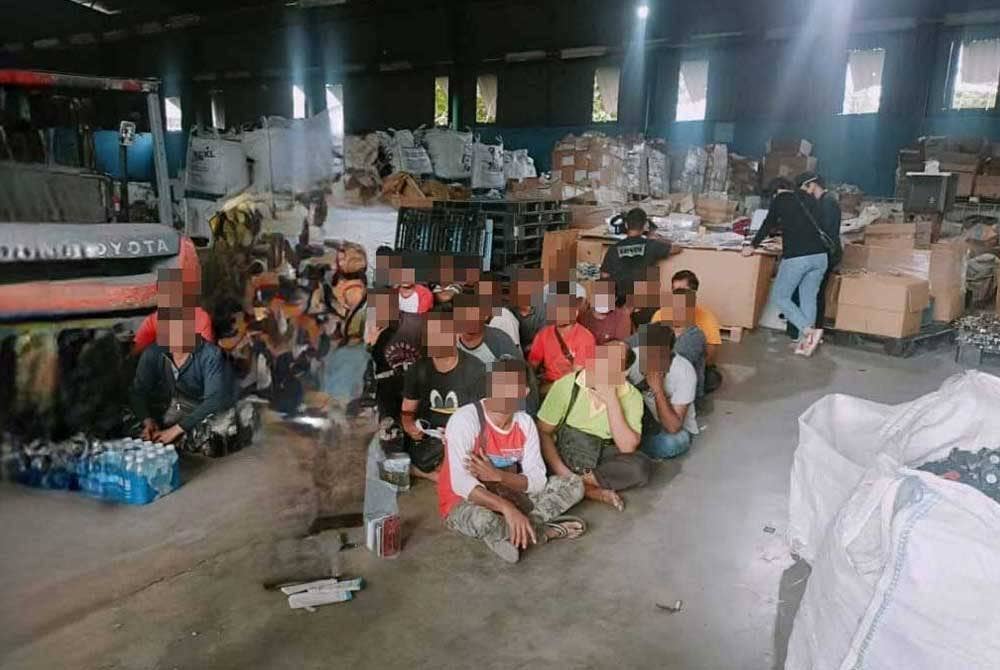 Antara warga asing yang ditahan dalam serbuan di sebuah kilang barangan terpakai di Kampung Jawa di sini pada Jumaat.