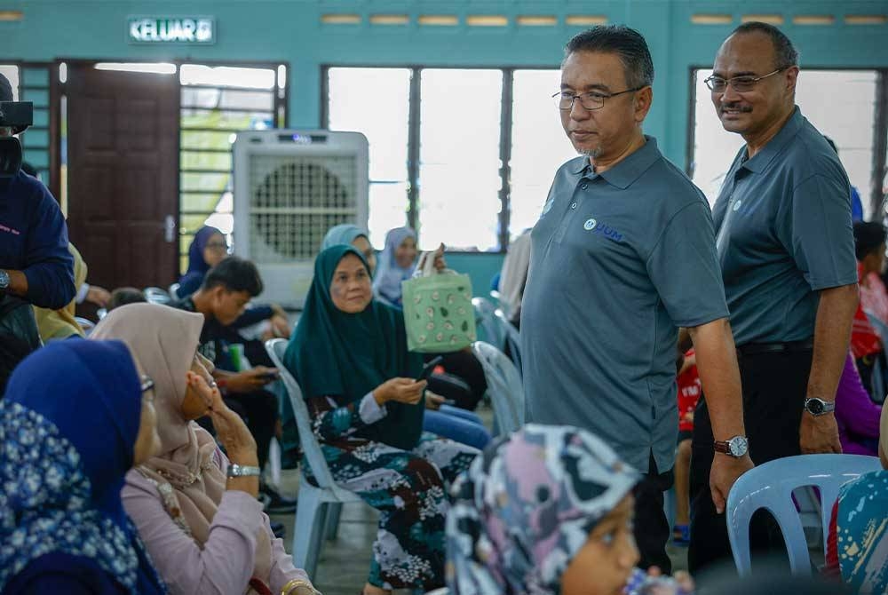 Adly Zahari (dua dari kanan) diiringi Pengarah Perkeso Melaka, Abd Razak Omar, meluangkan masa beramah mesra dengan orang ramai sempena Program Outreach & CSR Perkeso di Felda Tun Ghafar dekat Hutan Percha pada Sabtu. - Foto: Bernama