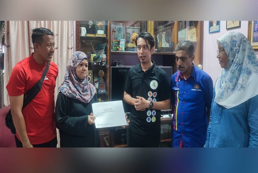 Timbalan Menteri Belia dan Sukan, Adam Adli Abd Halim (tengah) menyerahkan cek kepada balu Raja Libas Negara, Suraya Abdullah (dua,kiri) ketika penyerahan khairat kematian di kediaman Allahyarham Adnan Saidin di Taman Utama, di sini, pada Sabtu.