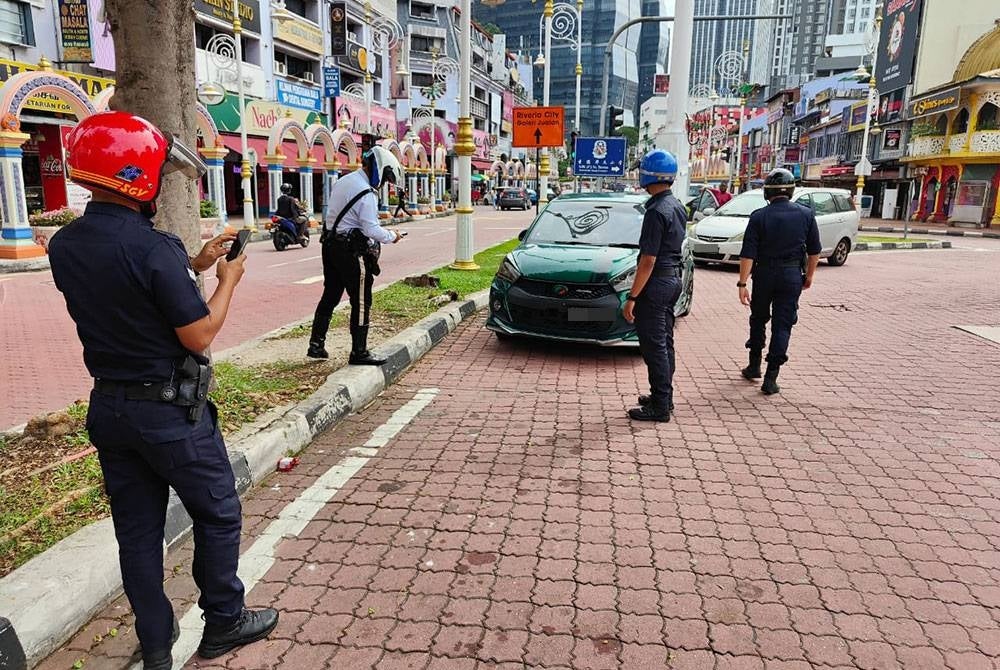 Anggota polis bertugas memantau sekitar jalan utama di ibu kota bagi memastikan peraturan jalan raya dipatuhi oleh pengguna.