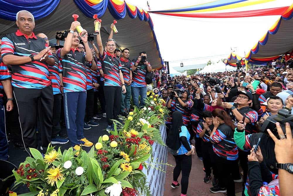 Fahmi Fadzil (tiga dari kiri) melepaskan para peserta Program 6,600 Langkah Perpaduan. - Foto Bernama