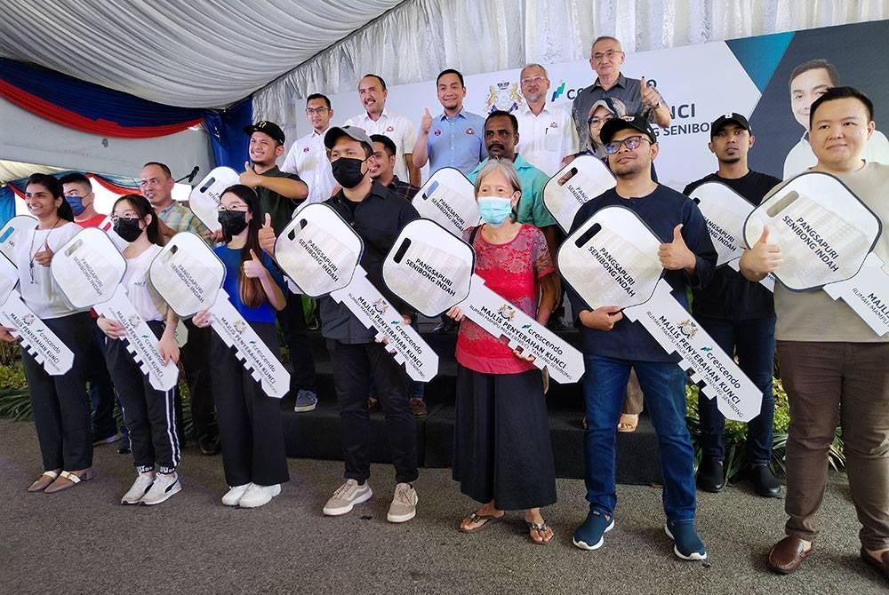 Onn Hafiz (belakang, tengah)bersama 15 penerima kunci Pangsapuri Senibong Indah, Tanjung Senibong, Masai pada Ahad.