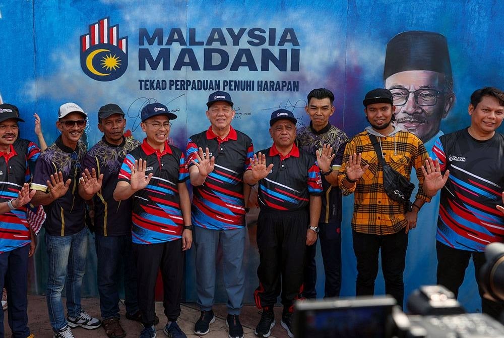Fadillah (tengah) bergambar kenangan bersama lukisan mural Malaysia Madani. - Foto Bernama