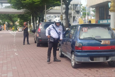 Anggota polis menasihatkan pengguna agar tidak menghalang laluan lalu lintas menerusi Ops Hormat Undang-undang jalan raya.