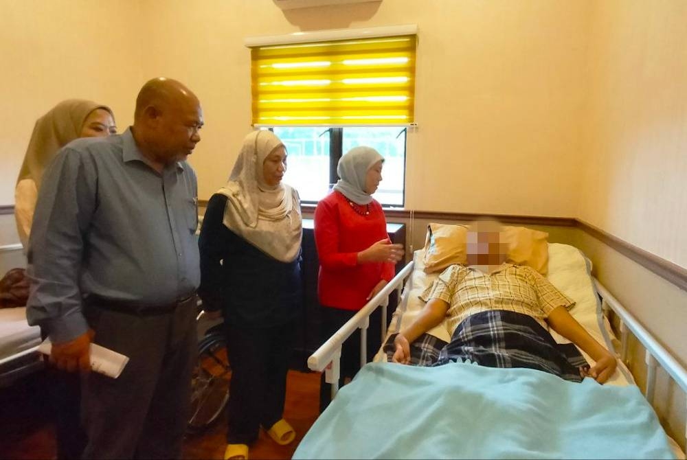 Nancy (kanan) menziarahi salah seorang penghuni Pusat Jagaan Damai Permai pada Isnin.