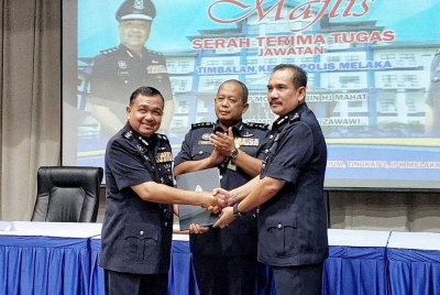 Zainol (tengah) menyaksikan jawatan Timbalan Ketua Polis Melaka oleh Mohamed( kiri) kepada Md Nazri (tiga,kiri) di (IPK) Melaka, Bukit Beruang di sini, pada Isnin.