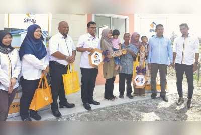 Akmal (empat dari kiri) bergambar selepas menyerahkan replika kunci kepada Nurafiqah (lima dari kanan) dan Siti Nor (tiga dari kanan) semasa Program Lawatan Tapak Projek RMR di Kampung Tali Air 7, Sekinchan pada Isnin.