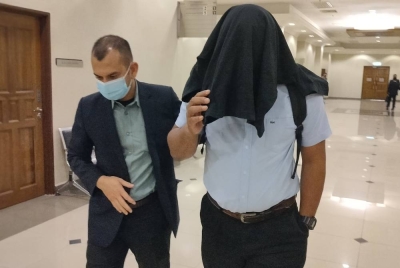 Tertuduh diiringi pegawai SPRM keluar dari mahkamah selepas mengaku salah dan didenda RM100,000 atas kesalahan mengemukakan invois palsu kira-kira dua tahun lalu.